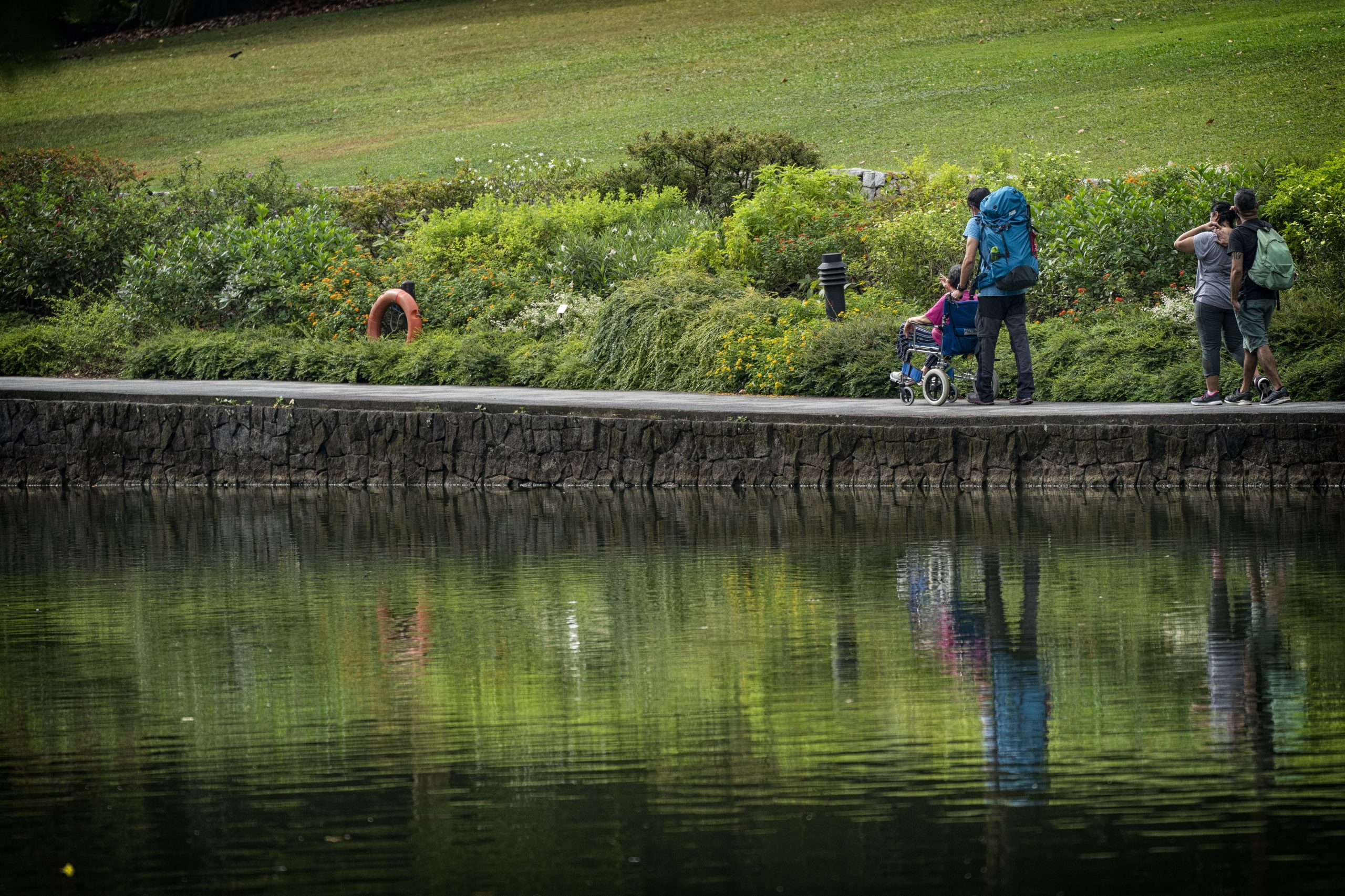 Mr Ding Kian Seng, 37, takes Madam Norah around Swan Lake at the Singapore Botanic Gardens, as part of a forest bathing programme, Nature Reconnections. He designed the programme for caregivers and their families, to help evoke a sense of wellbeing just by enjoying nature.